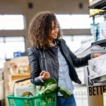 Personal budgeting and saving: a handwritten grocery list beside fresh produce on a kitchen counter